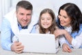 Close up portrait of parents and daughter using laptop in room Royalty Free Stock Photo