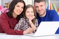 Close up portrait of parents and daughter using laptop in room Royalty Free Stock Photo