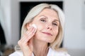Close up portrait of peaceful mid age woman cleaning face Royalty Free Stock Photo