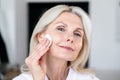 Close up portrait of peaceful mid age woman cleaning face