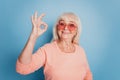 Close up portrait of pensioner promoter lady in sunglass show okey