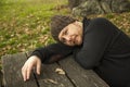 Close up portrait pensive man with wool hat laying on a bench. A Royalty Free Stock Photo