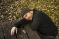 Close up portrait pensive man with wool hat lie down on a bench. Royalty Free Stock Photo