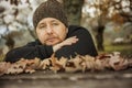 Close up portrait pensive man with wool hat sitting on a bench. Royalty Free Stock Photo