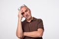 Close up portrait of pensive mature man in brown t-shirt. Royalty Free Stock Photo