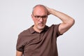 Close up portrait of pensive mature man in brown t-shirt. Royalty Free Stock Photo