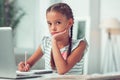 Close-up portrait photo of Afro-American lovely little schoolkid doing homework.