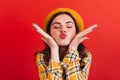 Close-up portrait of pink-cheeked girl sending air kiss. Woman in checkered blouse posing with closed eyes in romantic Royalty Free Stock Photo