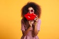 Close-up portrait of playful african wooman in sunglasses holding big red lips in front of her face, looking at camera Royalty Free Stock Photo