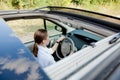 Close up portrait of pleasant looking female with glad positive expression, being satisfied with unforgettable journey by car,