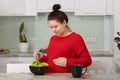 Close up portrait of pregnant woman cooking fresh green salad in kitchen, eating many different vegetables during pregnancy. Young Royalty Free Stock Photo