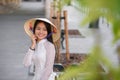 Close up portrait of pretty asian girl dressed in Ao Dai dress wearing vietnamese conical hat. Royalty Free Stock Photo