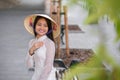 Close up portrait of pretty asian girl dressed in Ao Dai dress wearing vietnamese conical hat. Royalty Free Stock Photo