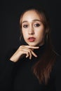 Close up portrait of pretty beautiful young woman wearing black sweater isolate over dark background