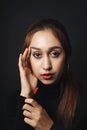 Close up portrait of pretty beautiful young woman wearing black sweater isolate over dark background. Beauty in the dark. Woman