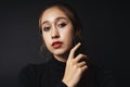 Close up portrait of pretty beautiful young woman wearing black sweater isolate over dark background. Beauty in the dark. Black