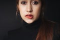 Close up portrait of pretty beautiful young woman wearing black sweater isolate over dark background. Woman using red lipstick.