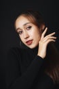 Close up portrait of pretty beautiful young woman wearing black sweater isolate over dark background