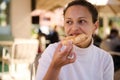 Close-up portrait of a pretty brunette, Latin American young woman eating a slice of delicious Italian pizza outdoor Royalty Free Stock Photo