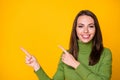 Close-up portrait of pretty confident cheerful girl pointing two forefingers aside copy space ad isolated bright yellow Royalty Free Stock Photo