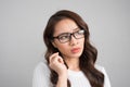 Close up portrait of pretty confident thoughtful girl, holding hand near the face, looking seriously up, standing over grey Royalty Free Stock Photo