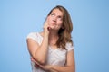 Close up portrait of pretty confident thoughtful girl looking like conspirator standing over grey background. Royalty Free Stock Photo