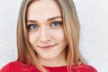 Close up portrait of pretty female with blue alluring eyes, freckled face and pure healthy skin looking directly into camera havin Royalty Free Stock Photo