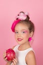 Close-up portrait of pretty girl with pink hairstyle with dragon fruit on pink background. Studio shot of charming tween Royalty Free Stock Photo