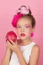 Close-up portrait of pretty girl with pink hairstyle with dragon fruit on pink background. Studio shot of charming tween Royalty Free Stock Photo