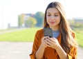 Close up portrait of pretty girl texting with cell phone outdoors Royalty Free Stock Photo