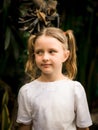 Close up portrait of pretty little girl. Blue eyes and blond hair. Caucasian girl with two ponytails. Dark brown background Royalty Free Stock Photo