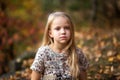 Close-up portrait of pretty little girl resting in autumnal park Royalty Free Stock Photo