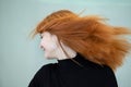Close up portrait of pretty redhead girl with long wavy hair blowing on the wind Royalty Free Stock Photo