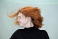 Close up portrait of pretty redhead girl with long wavy hair blowing on the wind Royalty Free Stock Photo