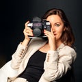 Close-up portrait of pretty woman photographer using digicam taking pictures snap isolated over black background with