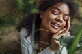 Close up portrait of pretty young african american woman lying on grass. Beautiful afro girl in relaxing in the park Royalty Free Stock Photo