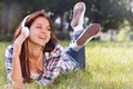 Close up portrait of Pretty young girl listening music lying at the grass Royalty Free Stock Photo