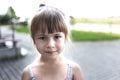 Close-up portrait of pretty young little blond pale unhappy moody friendless child girl looking sadly in camera on blurred sunny Royalty Free Stock Photo