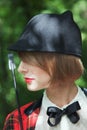 Close-up portrait in profile of beautiful young woman in horsewoman suit in forest