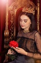 Close up portrait of queen sitting on throne with flower