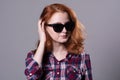 Close-up portrait of a red-haired beautiful woman wearing sunglasses Royalty Free Stock Photo