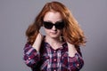 Close-up portrait of a red-haired beautiful woman wearing sunglasses Royalty Free Stock Photo