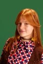 Close-up portrait of red haired cheerful, smiling young cowgirl, teenager looking at camera against green studio Royalty Free Stock Photo