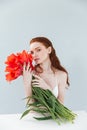 Close up portrait of a redheaded woman holding tulip flowers Royalty Free Stock Photo