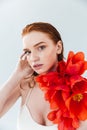 Close up portrait of a redheaded woman holding tulip flowers Royalty Free Stock Photo