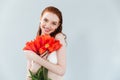 Close up portrait of a redheaded woman holding tulip flowers Royalty Free Stock Photo