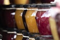 A close up portrait of rows of stacked glass pots with a metal black lid on them, with colorfull contents.