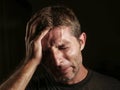 Close up portrait of sad and depressed man with hand on face looking desperate feeling frustrated and helpless crying miserable in