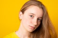 Close-up portrait of a sad girl. Studio portrait of a serious girl teenager on a yellow background Royalty Free Stock Photo