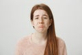 Close-up portrait of sad redhead caucasian girl with gloomy smile, whining or crying with frowned eyebrows and miserable Royalty Free Stock Photo